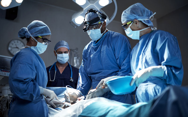 group of doctors performing surgery